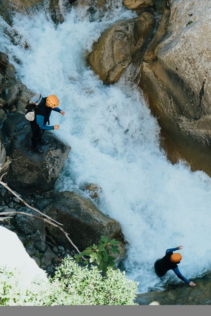 beautiful top angle shot people doing extreme sports over a river ina stony mountain